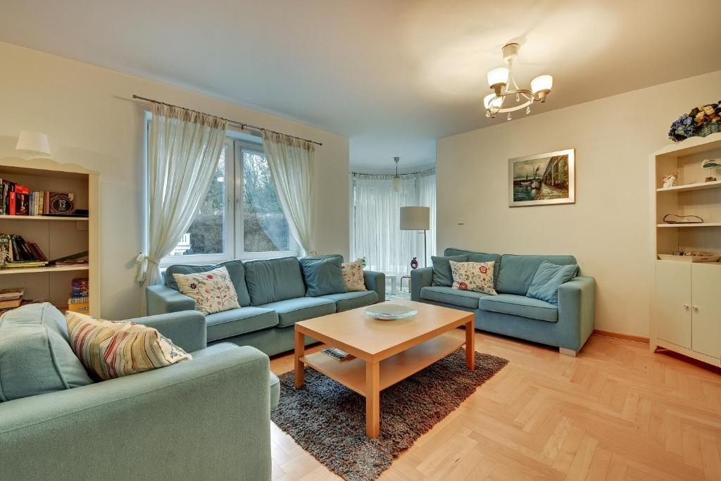 ソポトにあるGrand Apartments - Helskaのリビングルーム(青いソファ2台、テーブル付)