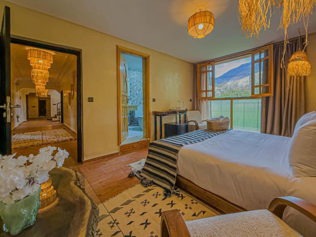 a bedroom with a large bed and a large window at Targa Imoula Luxe in Imlil