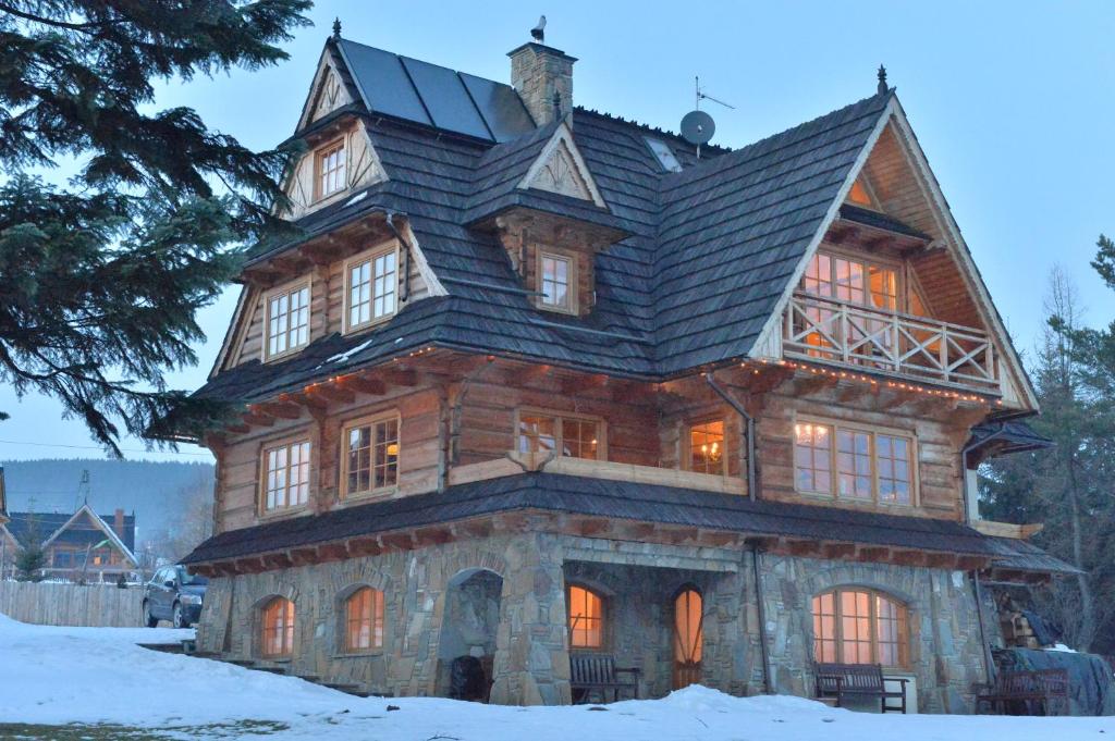 una gran casa de madera con techo de gambrel en Willa Saltaria, en Kościelisko