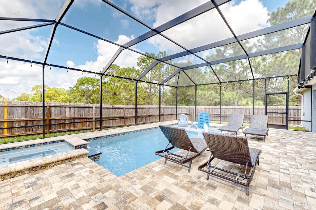 a patio with a table and chairs next to a swimming pool at Poolside Oasis! Family-Friendly Summerfield Escape in Orange Blossom Hills