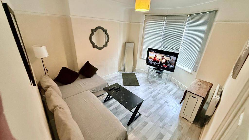 a living room with a couch and a flat screen tv at Stirling Steet in Wallasey