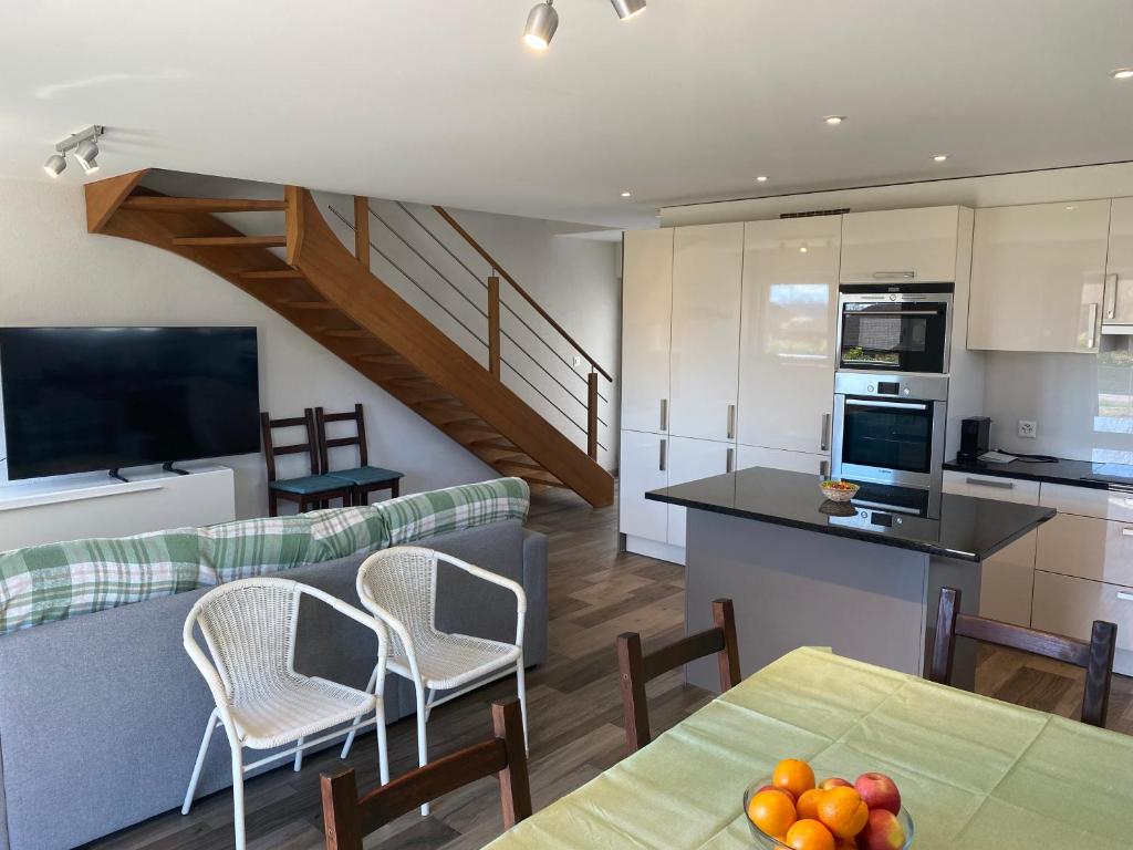 a kitchen and a living room with a table and chairs at Bell Air-Plus in Les Hauts-Geneveys