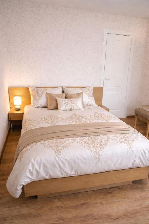 a bedroom with a large white bed with pillows at Apartamenti dzīvoklis Ogre. in Ogre