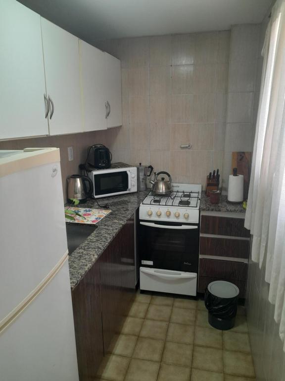 a kitchen with a stove and a microwave at Departamento in Mar del Plata