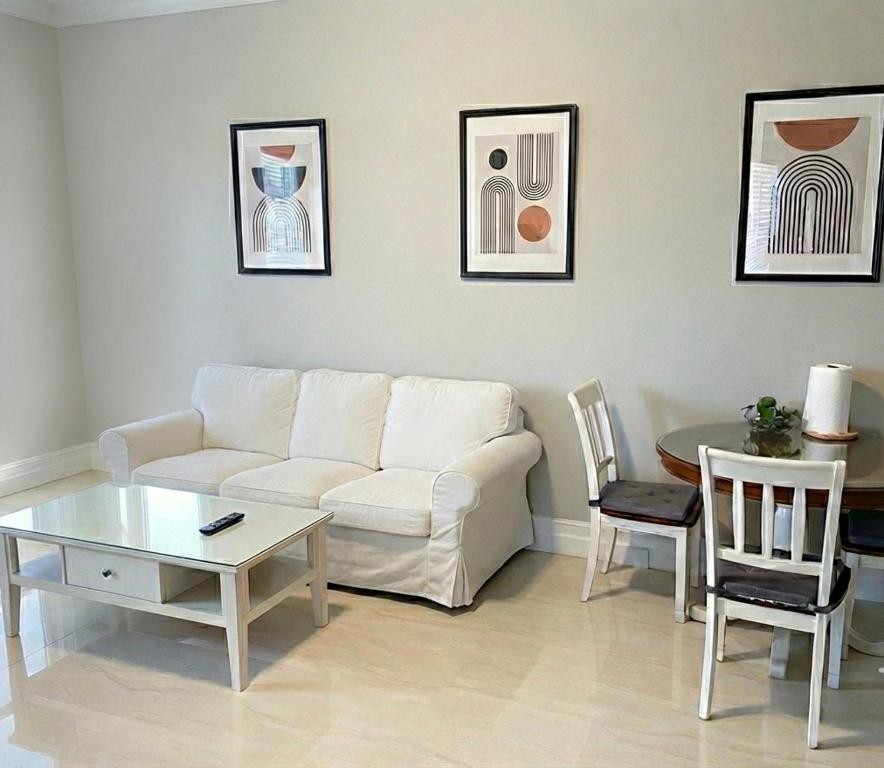 a living room with a white couch and a table at Richmond 2-Bedroom Luxry Suite in Richmond