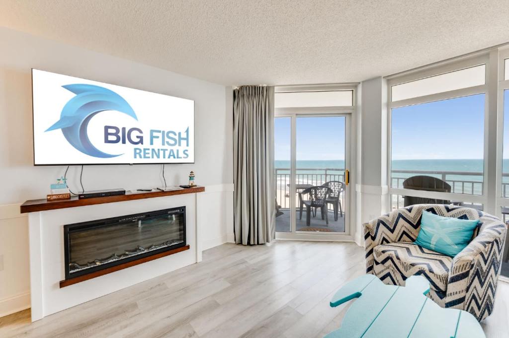 a living room with a fireplace and a tv at NEW Baywatch Remodled with Direct Oceanfront Views in Myrtle Beach