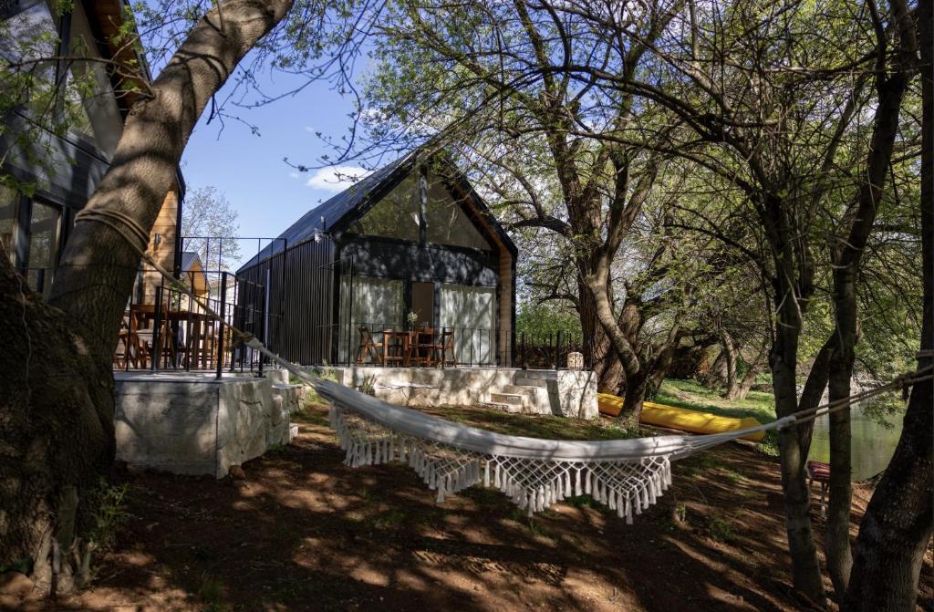 a hammock in a forest with a black building at Watan A&D in Buna