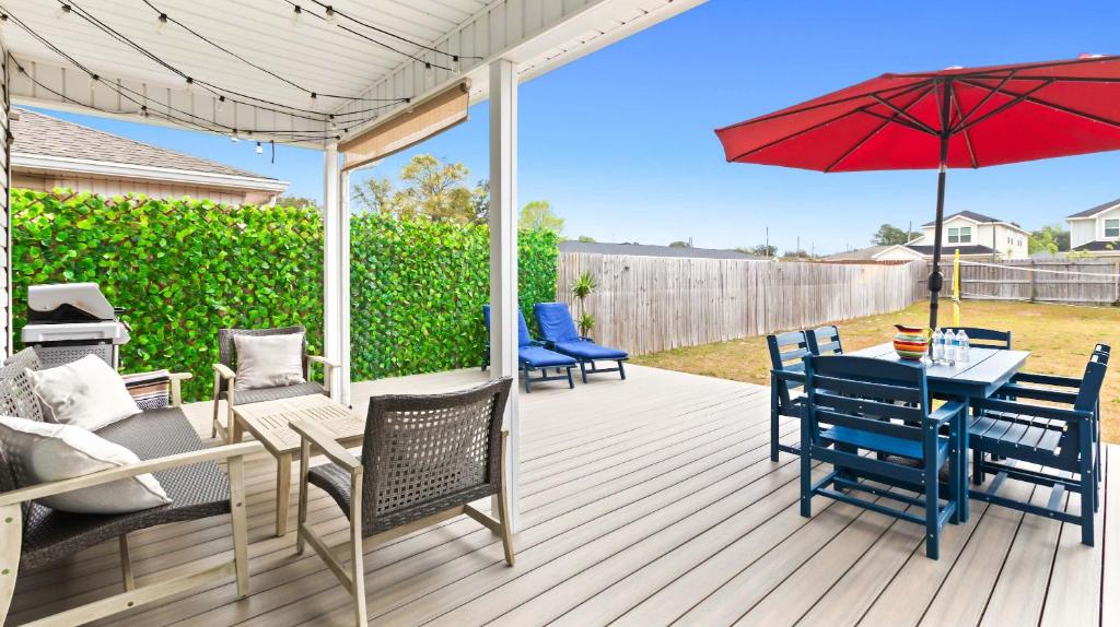 a patio with a table and chairs and an umbrella at New Home with Fenced Yard Large Deck & Fire Pit in Navarre