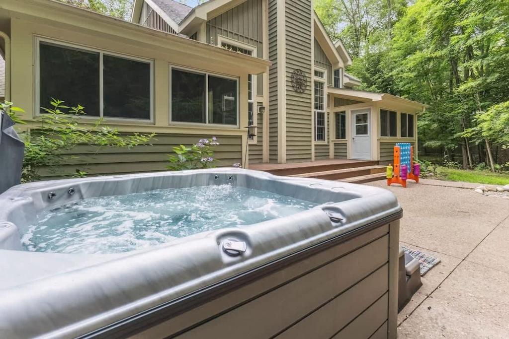 a hot tub in front of a house at Pete's Place by Juniper Holiday + Home in Sawyer