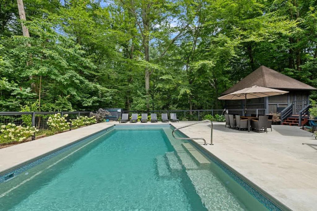 a swimming pool with a gazebo and a house at Gray Haven by Juniper Holiday + Home in Union Pier