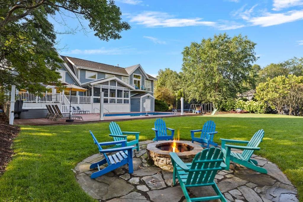 a group of blue chairs sitting around a fire pit at Main Destination by Juniper Holiday + Home in Grand Beach