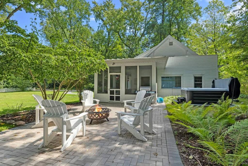 a patio with white chairs and a fire pit at Whispering Arbor by Juniper Holiday + Home in Lakeside