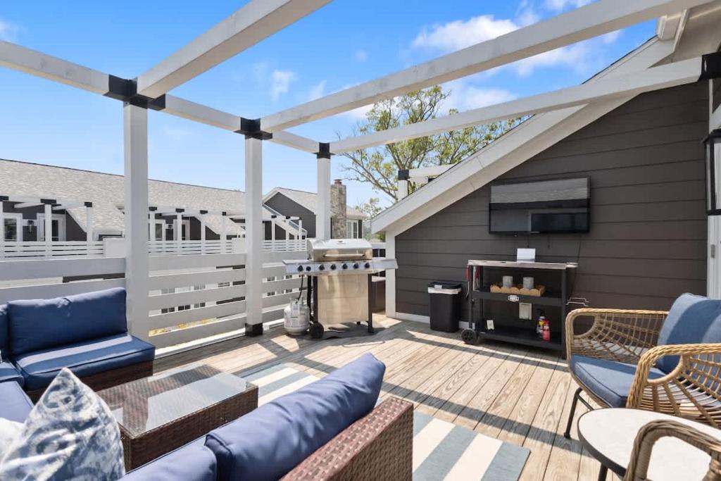 a deck with a patio furniture and a grill at The Happy Place by Juniper Holiday + Home in Union Pier