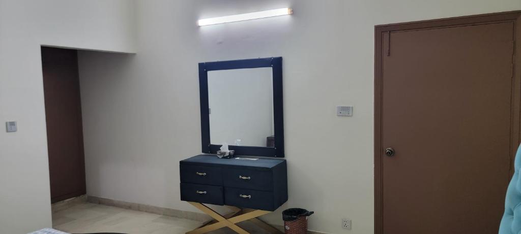 a bedroom with a mirror and a blue dresser at UrbanNOOK Basic in Rawalpindi