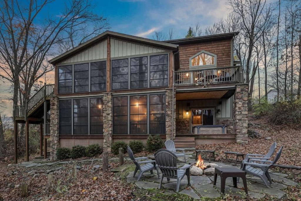 a house with a fire pit in front of it at Lodged in the Trees in New Buffalo