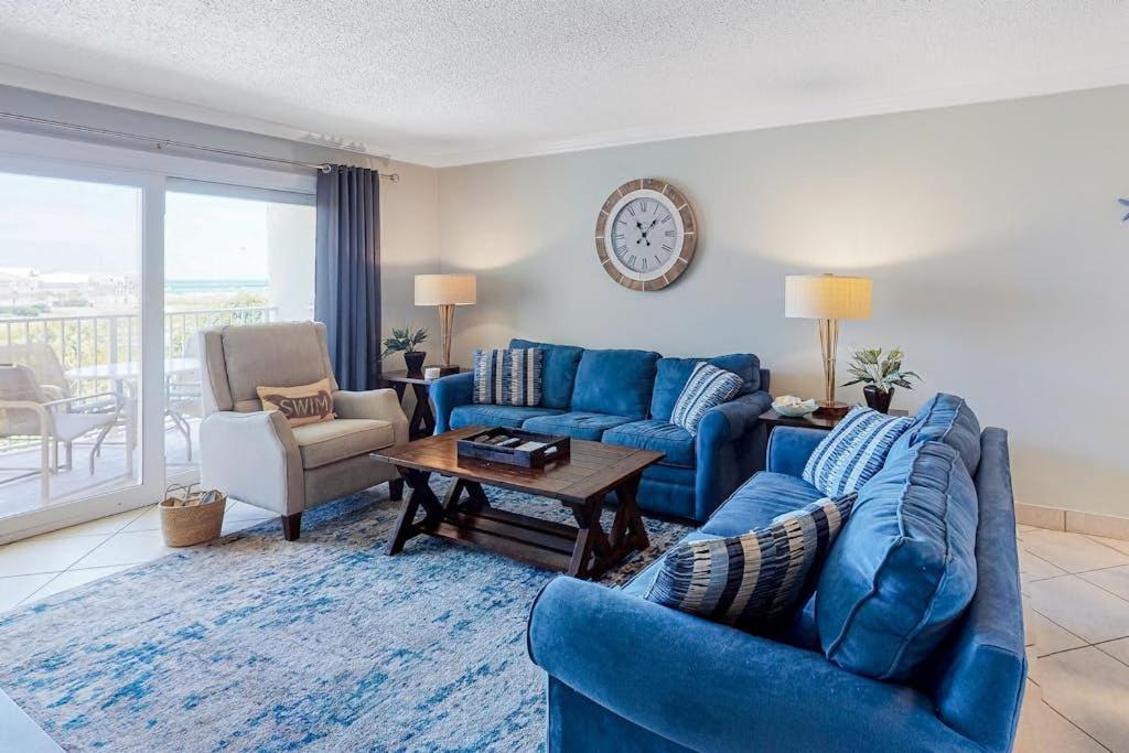 a living room with two blue couches and a table at Condo in oceanfront complex with pools private beach access and balcony in Destin