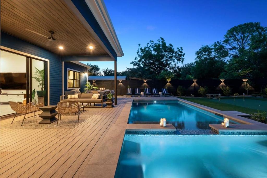 a backyard with a swimming pool and a deck at Stylish Southern Home with Heated Pool in Austin
