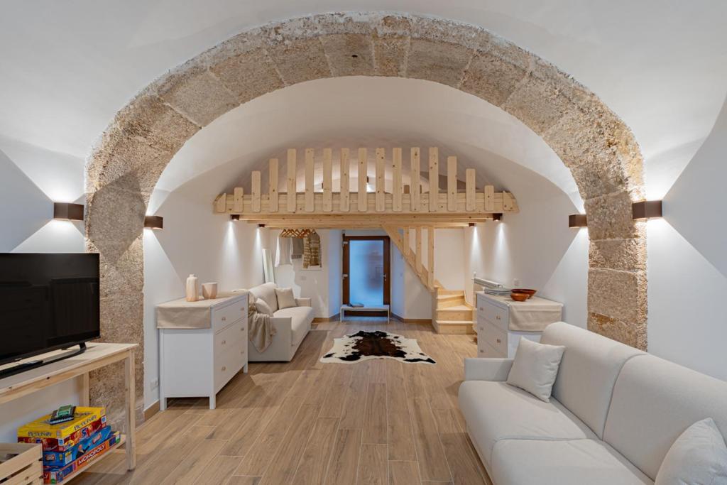 a living room with a white couch and an archway at Casa Caniglia 34 - YourPlace Abruzzo in Rivisondoli