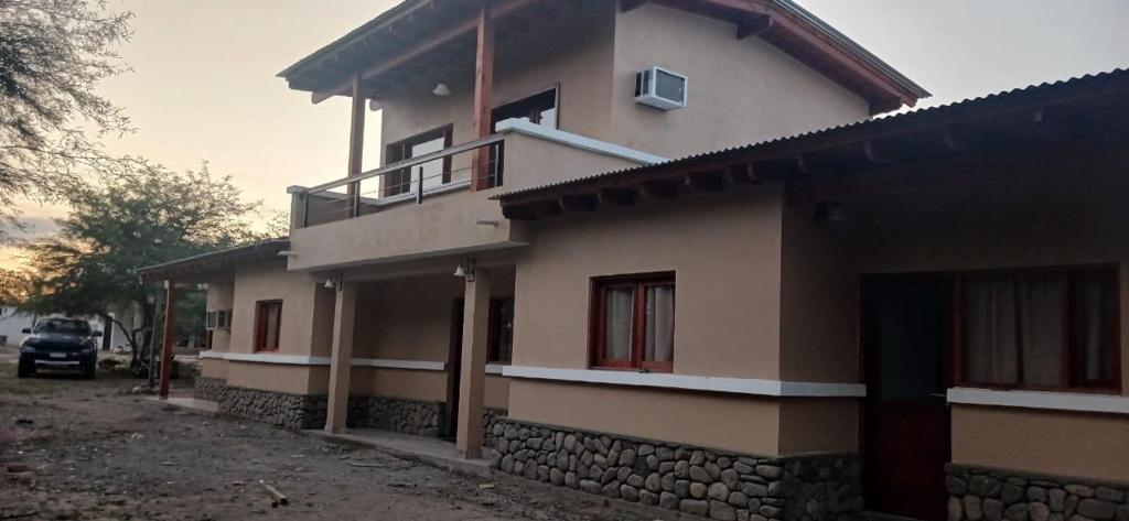 a house with a car parked in front of it at Cabañas Termales in Termas de Río Hondo