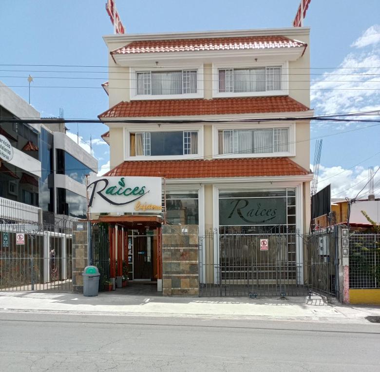 a building with a rakes store on the side of a street at Hotel Raices in Ambato