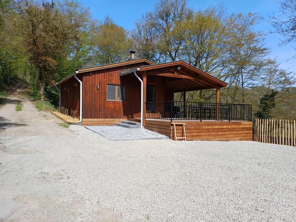 a wooden cabin with a porch and a fence at Vue sur Ourthe in Durbuy