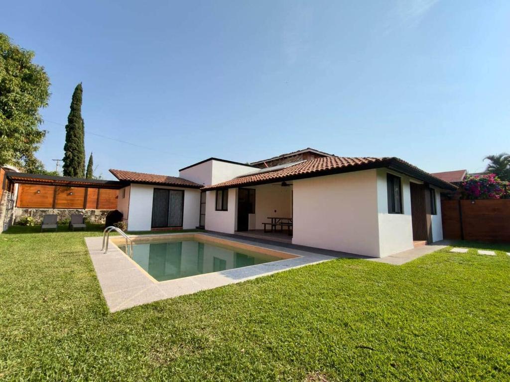 a house with a swimming pool in the yard at Casa a una cuadra del centro comercial in Oaxtepec