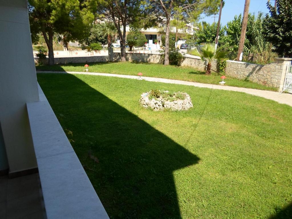 a shadow of a building on a lawn at Hotel Villa Basil in Tsilivi