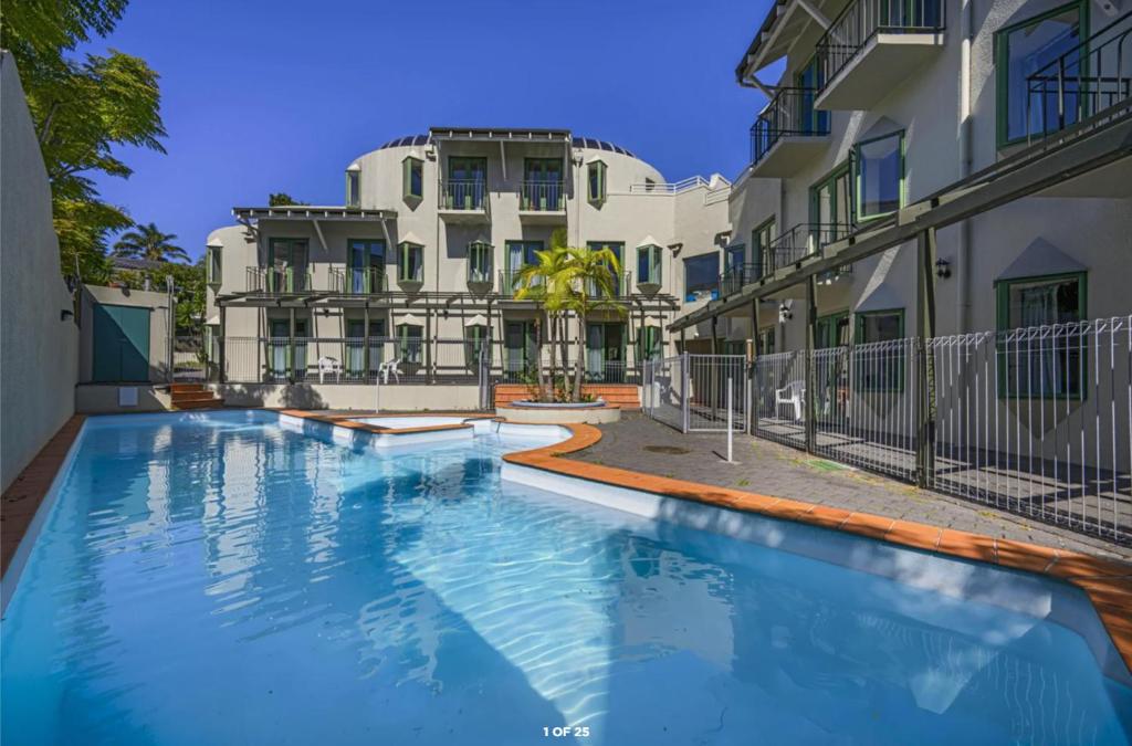 a swimming pool in front of a building at Parklane Motor Lodge in Auckland