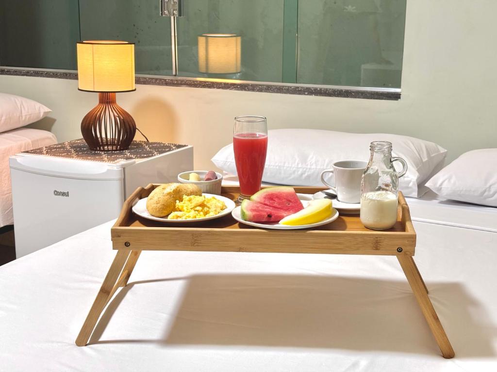 a tray of breakfast food on a table on a bed at Julietta House Hotel in Manaus