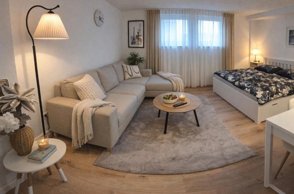 a living room with a couch and a bed at Cozy Suite Kirchheim, Parkplatz, Nähe A8, Souterrain in Kirchheim unter Teck
