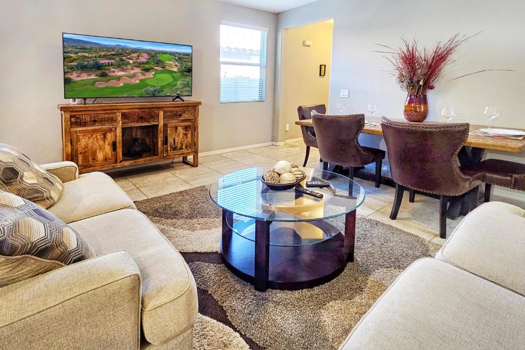 a living room with a table and a tv at Spacious Desert Suite Minutes to Phoenix Fun - Pet Friendly! in Avondale
