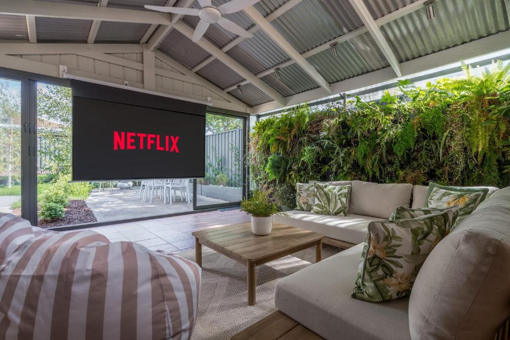 a living room with a tv with a netflix sign at Ohana Coastal Escape in Rosebud