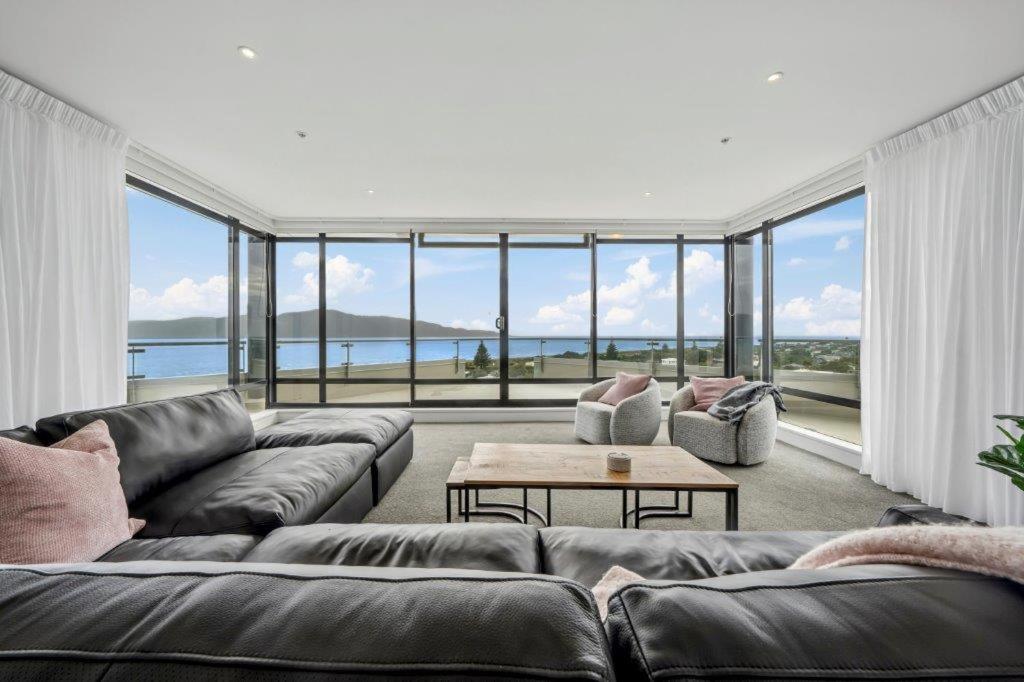 a living room with a couch and a table at U Suites at The Links in Paraparaumu
