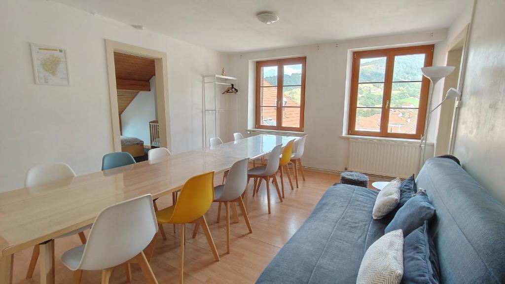 a living room with a table and a blue couch at Duplex avec vue au centre de Bussang in Bussang