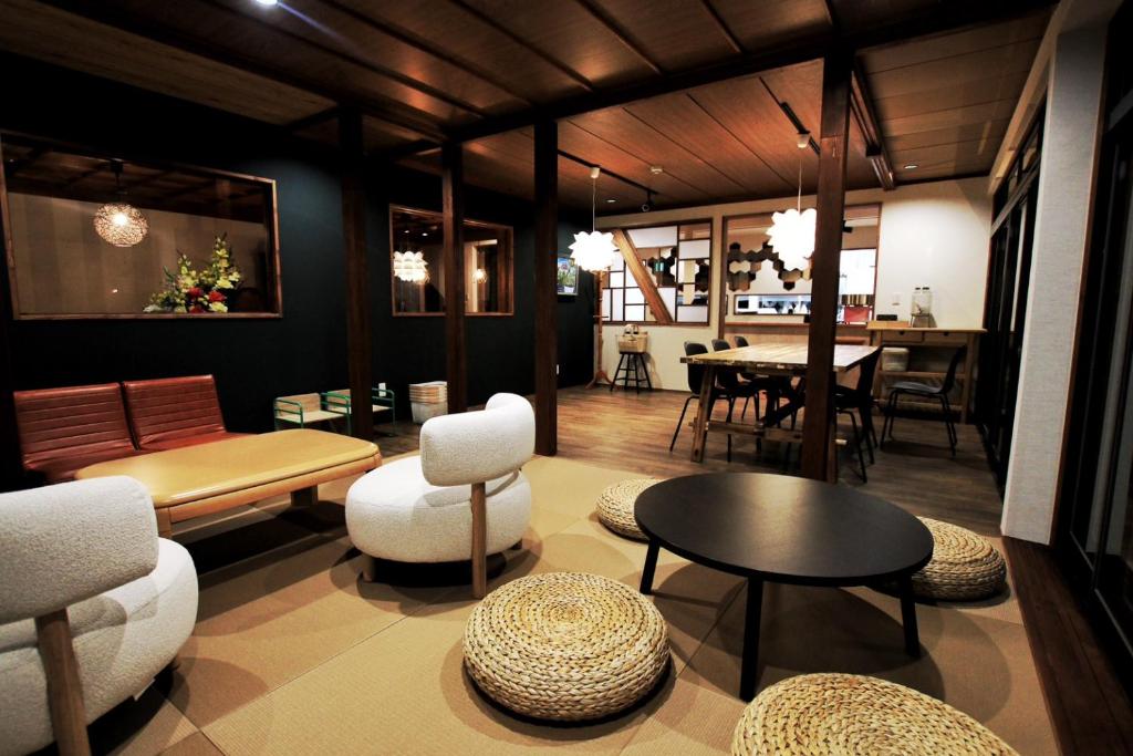a living room with white furniture and a table at SAKADONEguesthouse in Iijima