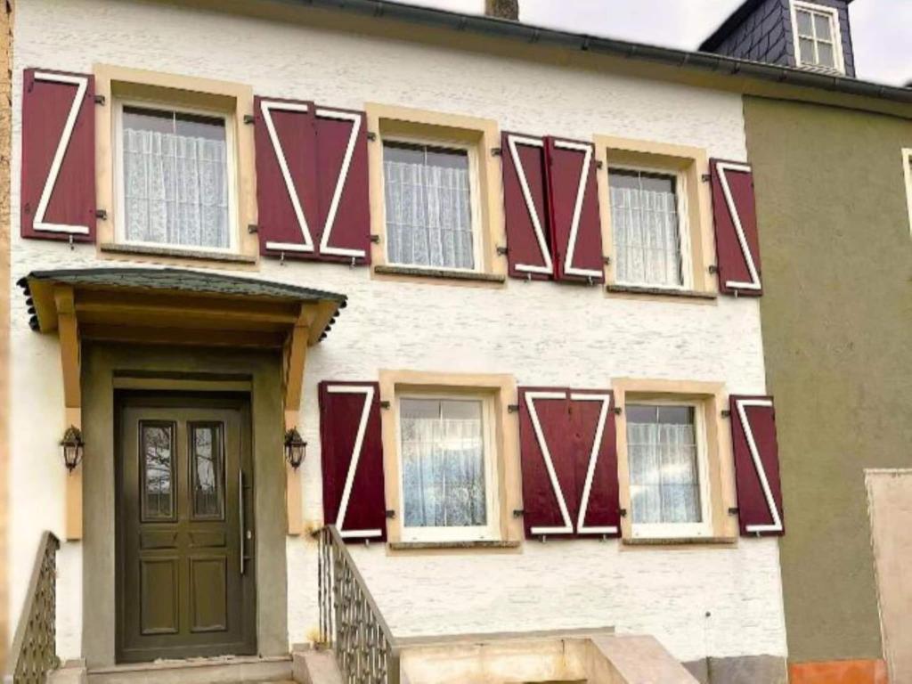 a house with red windows and a door at Holiday Home in Konz in Konz