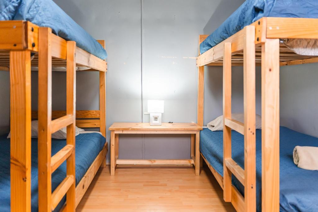 a room with two bunk beds and a desk at Patagonia Sweet House in Puerto Natales