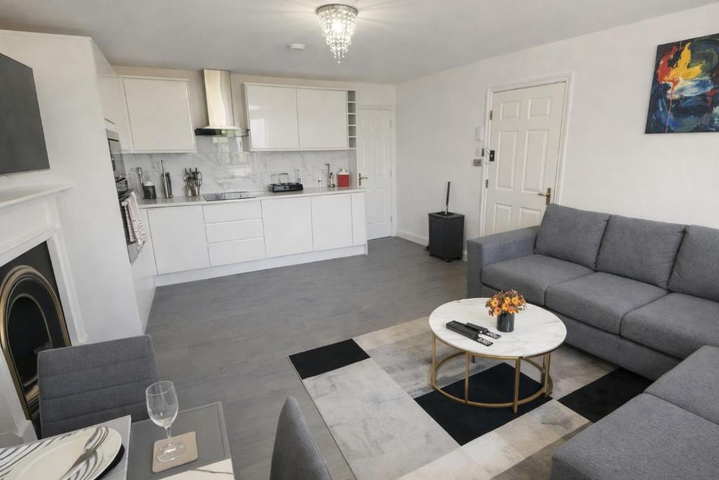 a living room with a couch and a table at Entire Apartment hosted by Pius in Redhill