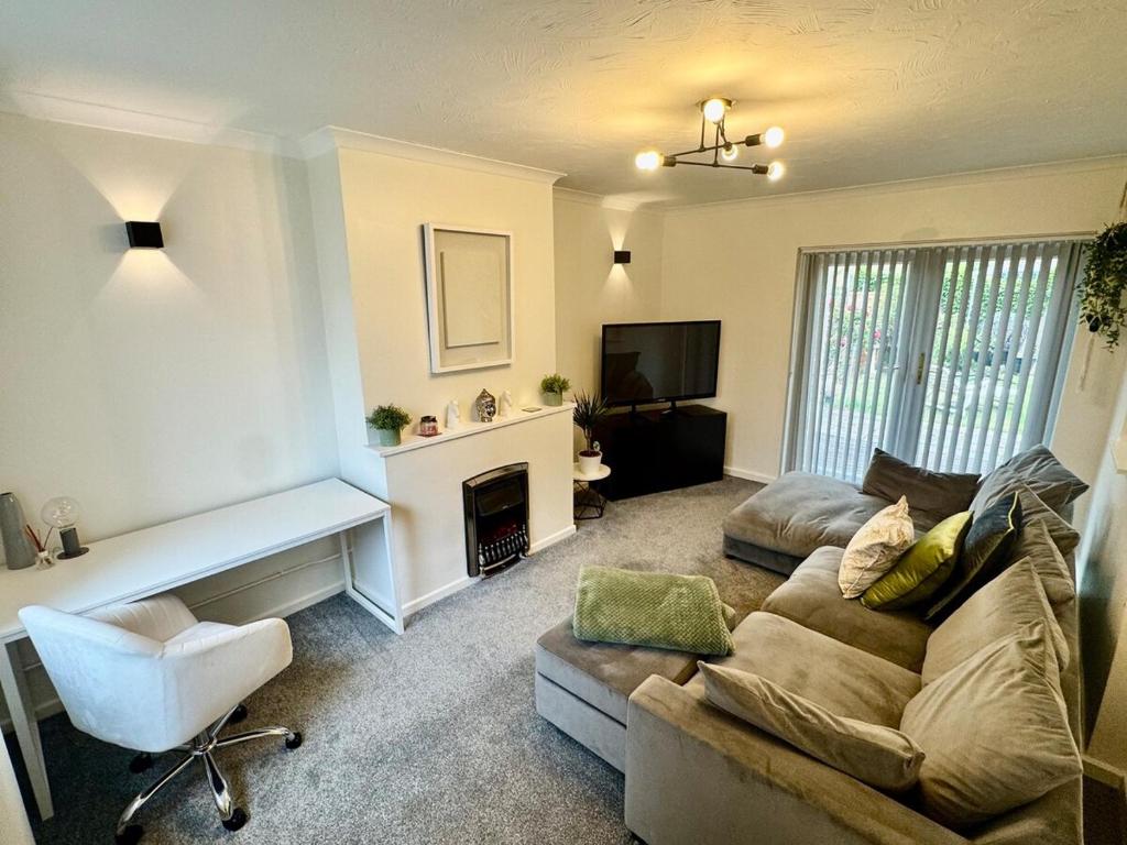 a living room with a couch and a fireplace at Comfortable 3BR house-parking close to city centre in Kidlington