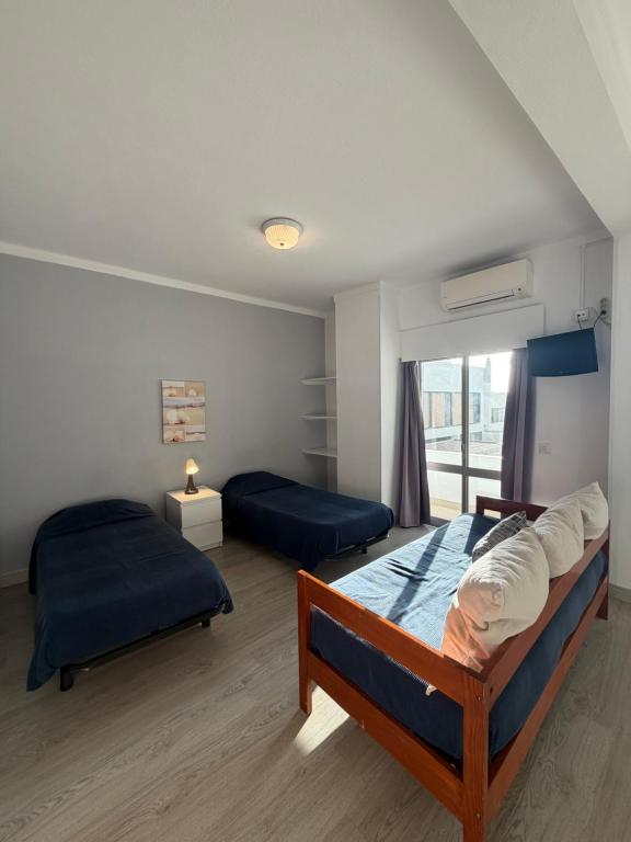 a bedroom with two beds and a window at PontesMar Apartamentos Central in Quarteira