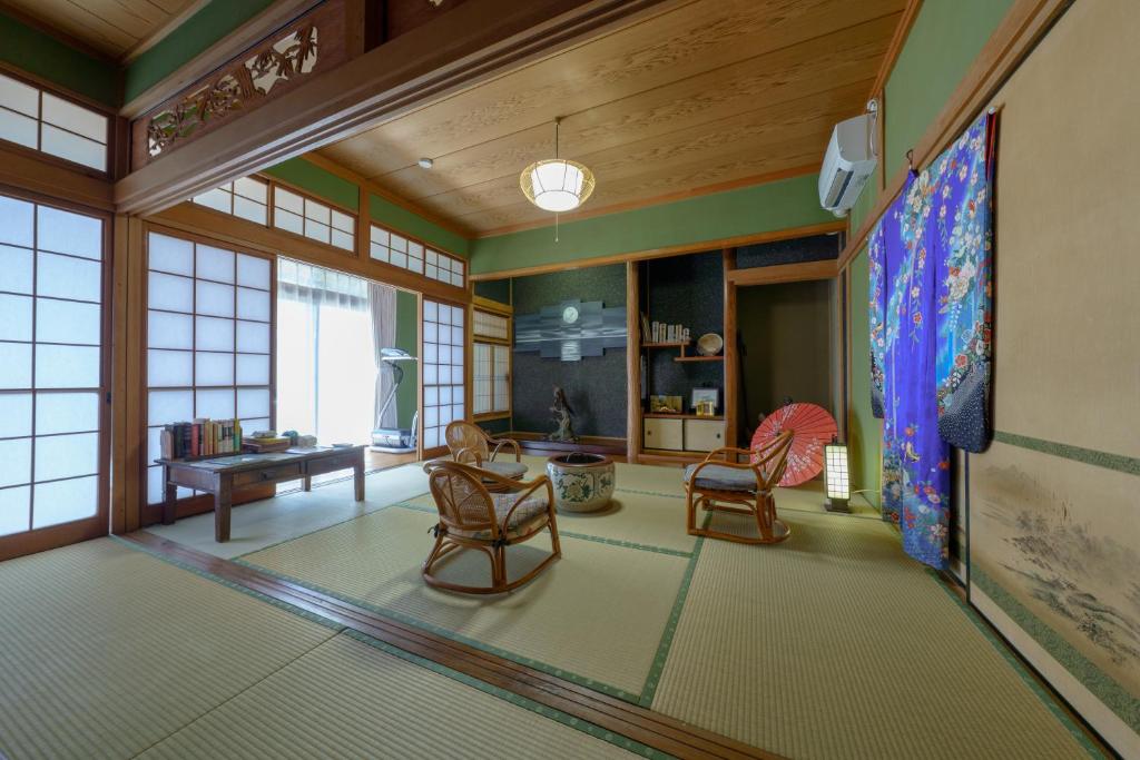 a living room with chairs and a table at ようこそ月の宿へ in Shindembaru