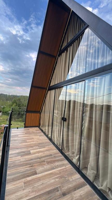 a balcony with a large glass door on a building at Chalé Amor & Serra in Lauro Müller