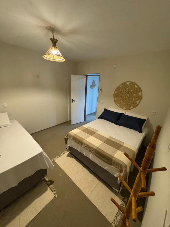 a bedroom with a bed and a chandelier at Pousada Raízzes in Amontada