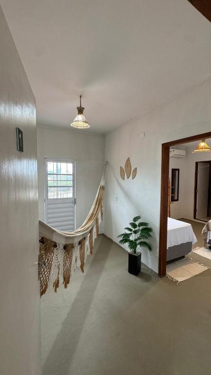 a bedroom with a bed and a hammock in a room at Pousada Raízzes in Amontada