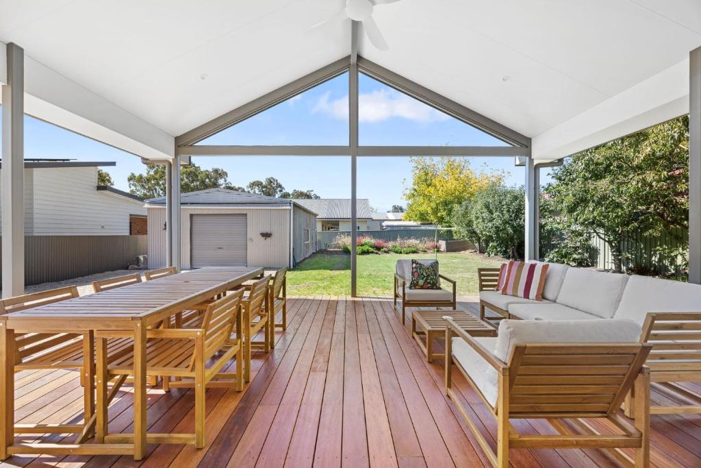 a patio with a table and chairs and a couch at Timber Mill Cottage - Mansfield in Mansfield