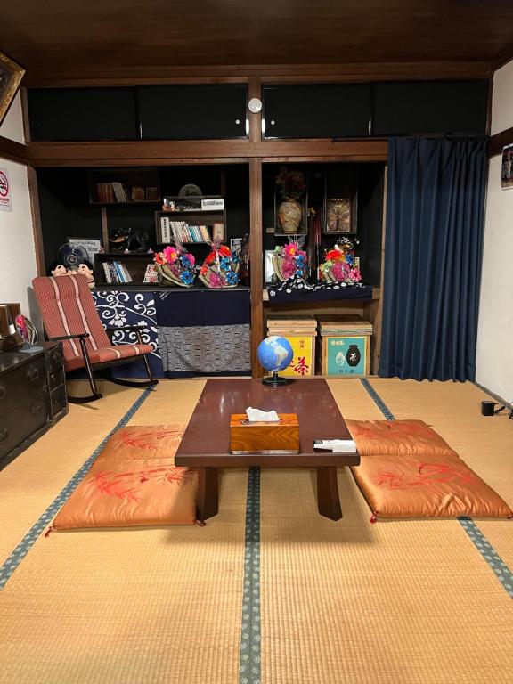 a living room with a table and a couch at Lodging House NAO in Aomori