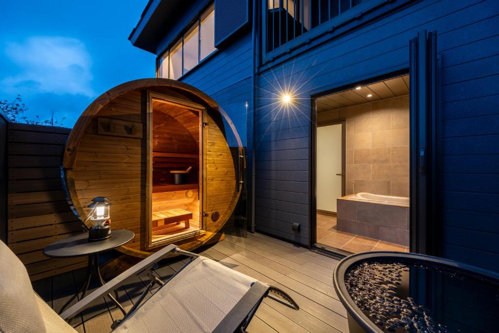 a patio with a tub and a table and a chair at KomoreNest伊豆熱川 in Higashiizu