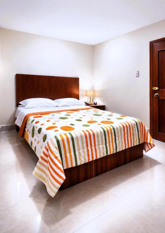 a bedroom with a bed with a colorful blanket on it at Habitaciones Sky in Manta