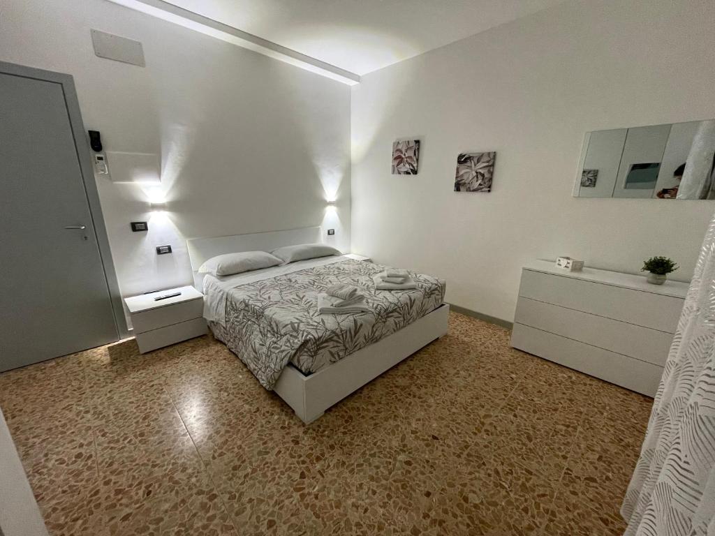 a white bedroom with a bed and a dresser at Rifugio Urbano in Terni