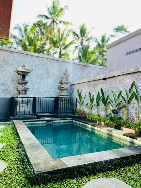 a swimming pool in the yard of a house at Sedana Pertiwi House in Ubud